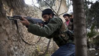 Syrian rebel fighters fire at a Syrian army position in Aleppo province (13 December 2012)