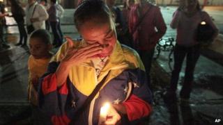 A woman holding a candle for Chavez