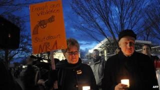 Gun control supporters take part in a candlelight vigil at Lafayette Square across from the White House on 15 December 2012, Washington