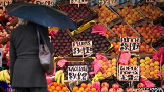 Woman surveys fruit for sale at a market