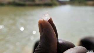 A diamond prospector shows a diamond stone in Koidu, Sierra Leone (28 April 2012)