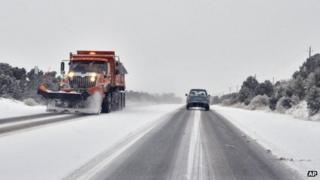 Drivers make their way cautiously in a snow storm along The Old Las Vegas Highway in Santa Fe 17 December 2012