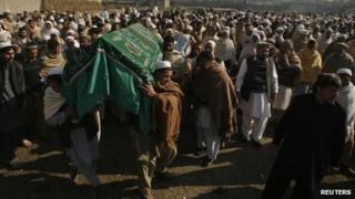 People carry the coffin of an aid worker who was killed by unidentified gunmen, during her funeral in Swabi January 2, 2013.