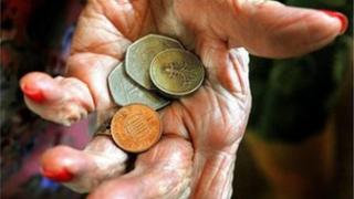 Elderly hand holding coins