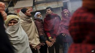 Indian laborers warm themselves on a fire in a market on a cold morning in New Delhi, India, Monday, Jan 7, 2013.