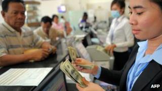 Employees counting money at a bank in Cambodia