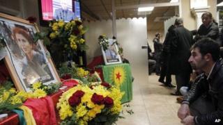 A man reacts next to portrait of Sakine Cansizt inside the Kurdish cultural center in Paris