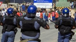Police observer striking farm workers in South Africa's Western Cape province on 9 January 2013