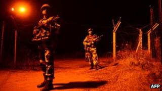 Indian Border Security Force (BSF) soldiers patrol along the border fence at an outpost along the India-Pakistan border in Abdulian, 38 kms southwest of Jammu, on January 17, 2013.