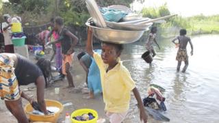 People washing up and bathing in the river near Lampsar, Senegal