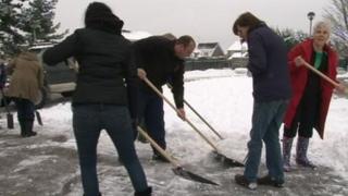 People clearing snow at The Arbours Primary School
