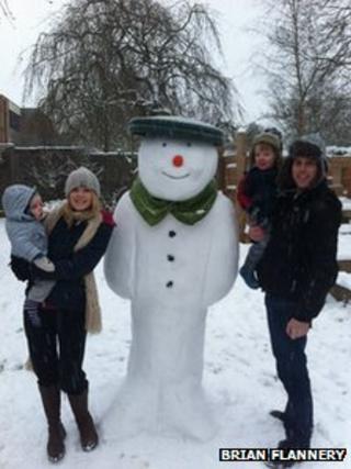 Brian Flannery with Shauna and a snowman built for Jack and William Flannery in Dorridge