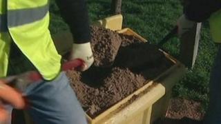 Grit salt being shovelled from a grit bin