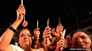 Group of women holding up their knives given by the Shiv Sena