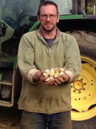 Mark Botwright holding bulbs of garlic