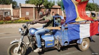 A man drives a motorbike in Mali's capital, Bamako, decorated with French flags among others to show his support for the international forces -24 January 2013