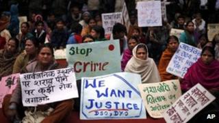 Group of demonstrators hold placards during a protest against the alleged inaction by the Indian government in the case of the gang rape of a 23-years old student in a bus in December