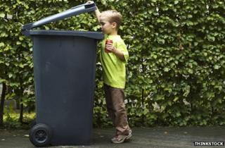 Boy putting a can in a bin