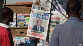 Men look at the front pages of newspapers on January 21, 2013 in a street of Bamako.