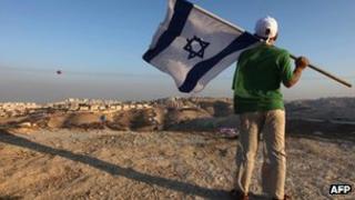 Israeli boy holds his national flag during a protest near the Jewish settlement of Maale Adumim, east of Jerusalem, in 2009