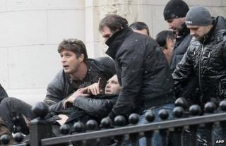 Bodyguards carry Zlatomir Ivanov to safety after he was shot in front of the Supreme Court of Appeal in Sofia, 29 January