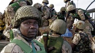 Nigerian soldiers unload their equipment as they arrive at the Mali air force base near Bamako 19 January 2013
