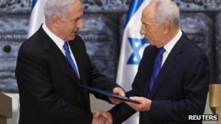 Israeli Prime Minister Benjamin Netanyahu (L) receives a folder from President Simon Peres at the president's residence in Jerusalem on 2 February 2013