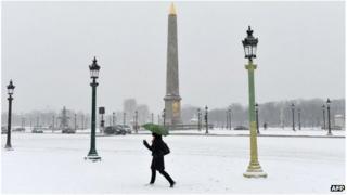 A woman walks on the snow covered Place de la Concorde, Paris