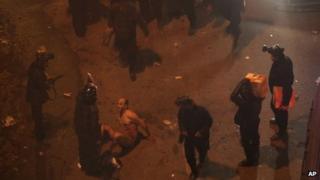 Egyptian riot police beat naked Hamada Saberon 1 February 2013 in Cairo