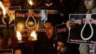 Indian students and activists shout slogans as they carry torches at India Gate following the gang-rape of a student in New Delhi.