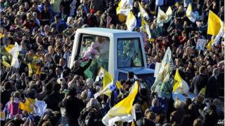Pope Benedict XVI kisses a baby while at an open-air Mass in Poland, 2010