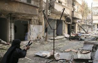 An opposition fighter uses a catapult to launch a handmade grenade in Aleppo, Syria, 12 February