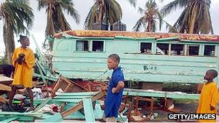 Children among debris of their storm-damaged school in 2004