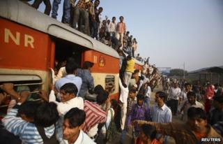 Commuters struggle to board a train at Noli railway station in Uttar Pradesh November 10, 2012.