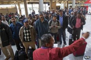 Pakistani and Indian employees of subcontracters working for British oil giant BP in Algeria listen to a man giving informations as they wait for their flight back to Dubai at the Palma de Mallorca airport on January 18, 2013.