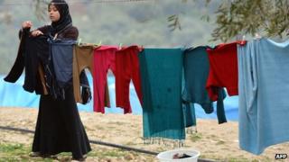 A displaced Syrian refugee her washed clothes at the refugee camp of Qah along the Turkish border in the village of Atme in the northwestern province of Idlib, on January 31 2012.