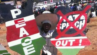 A person holding up signs calling for peace and ending hate speech at a peace concert in Nairobi, Kenya, 28 February 2013