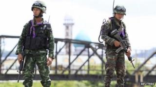 Soldiers hold their weapons at a checkpoint in the troubled southern province of Yala, 28 February 2013