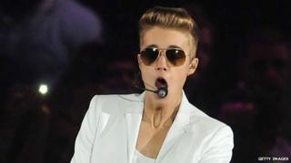 Justin Bieber wearing sunglasses indoors.
