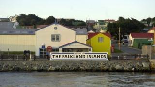 Shot of houses with a Welcome to the Falkland Islands sign in front