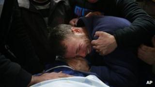 Palestinians relatives and friends cry next the dead body of Mohammed Asfour, 22, at the Ramallah Hospital in the West Bank city of Ramallah, 7 March 2013