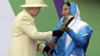 Y Frenhines yn cyflwyno'r baton i Prathibha Devi Singh Patil, Arlywydd India, cyn y Gemau yn Delhi yn 2010a