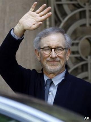 Director Steven Spielberg waves to the media as he leaves Indian Industrialist Anil Ambani"s office in Mumbai, India, Monday, March 11, 2013.