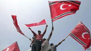 Acehnese men wave Crescent-Star flags during a rally outside Baiturrahman Grand Mosque in Banda Aceh, Aceh province, Indonesia, Monday, April 1, 2013.
