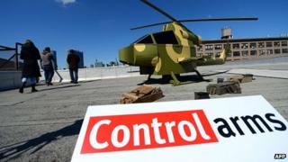 Arms treaty activists with replica of military helicopter. 27 March 2013