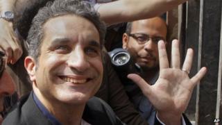 Popular Egyptian television satirist Bassem Youssef, who has come to be known as Egypt"s Jon Stewart, waves to is supporters as he enters Egypt"s state prosecutors office