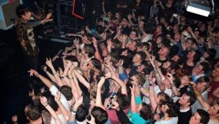 Fans take pictures on their mobiles as Bring Me The Horizon perform
