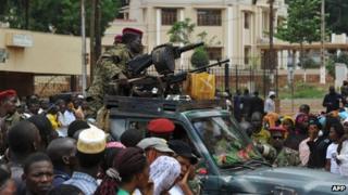 Seleka rebels sitting on a pick-up truck next to machine-guns as a crowd gathers in Bangui on 30 March 2013