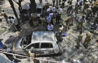 Police and forensic officials inspect the scene of a blast near the office of India"s main opposition Bharatiya Janata Party (BJP) in the southern Indian city of Bangalore April 17, 2013.