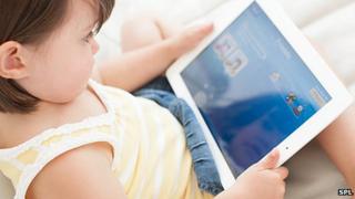 Young child playing with a tablet